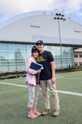 A mother and son stand on the practice 场 of the P1FCU-Kibbie Activity Center.